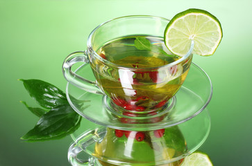 green tea in transparent cup with lime and berry