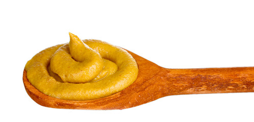 Mustard in wooden spoon isolated on white
