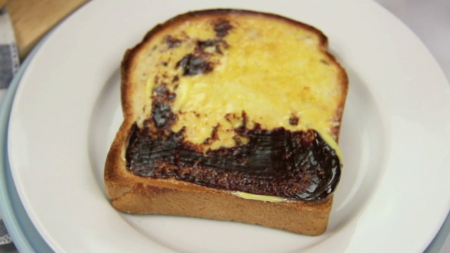 Vegemite being spread on to a hot toast slice