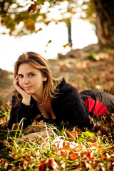 jeune femme dans les feuilles d'automne