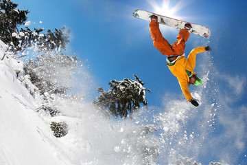 Snowboarder jumping against blue sky - obrazy, fototapety, plakaty