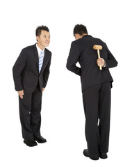 two asian businessman bowing and holding hammer behind