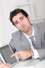 Businessman showing something on laptop computer