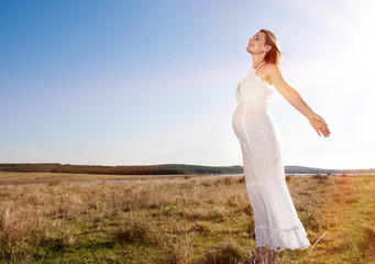 Fototapeta na wymiar Pregnant woman standing on field