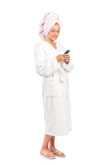 Young woman in bathrobe holding a mobile phone