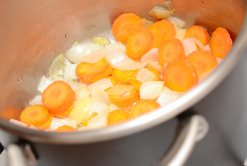 Carrot and onion with oil in pan