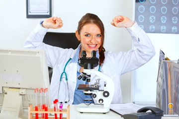 Smiling female medical doctor sitting in laboratory