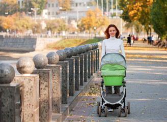 Happy young mother with baby in buggy