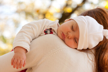 Sleeping little girl on mother's shoulder