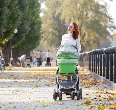 Happy young mother with baby in buggy
