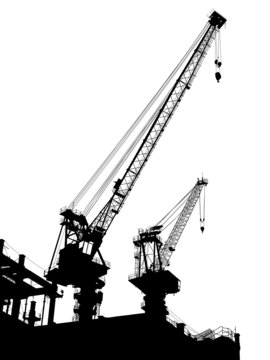 Silhouettes of two cranes on building