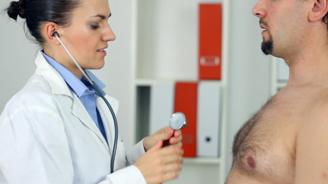 Female doctor examining patient chest with a stethoscope