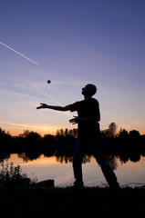 Silhouette of Yo-Yo player on the lake shore