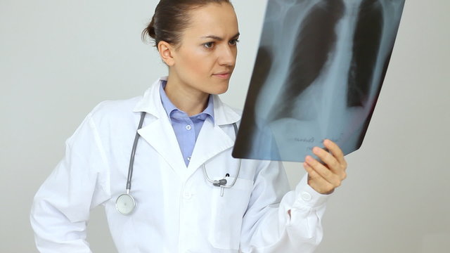 Female doctor looking at xray of human lungs, isolated