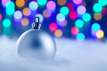 Christmas silver bauble in blurred lights