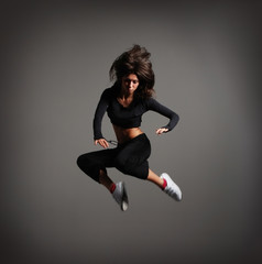 Fototapeta na wymiar A young brunette woman caught in a beautiful jump