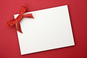red gift tag tied with a bow of red satin ribbon