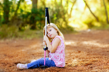 Hiking kid girl tired sitting in autumn forest