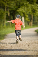 Kind läuft auf Schotterweg