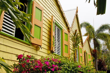 Fototapeta na wymiar Yellow Tropical Building with Orange and Green Shutters
