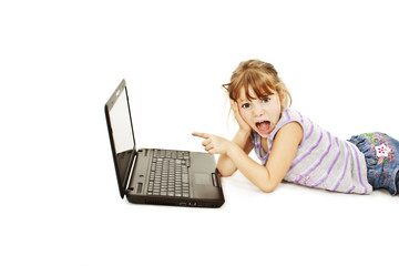 Surprised little girl with laptop. Pointing at it