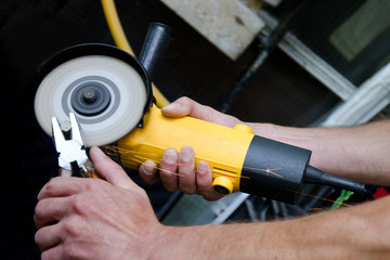 A worker holds a professional angle grinder