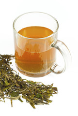 tea in glass cup and leaves on white