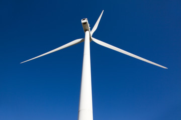 white wind turbine generating electricity on blue sky