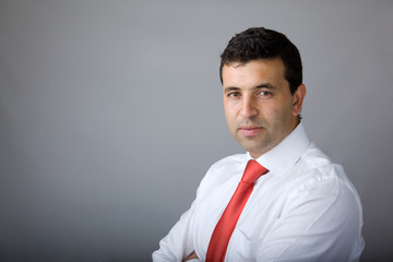 Portrait of a handsome young business man on grey background