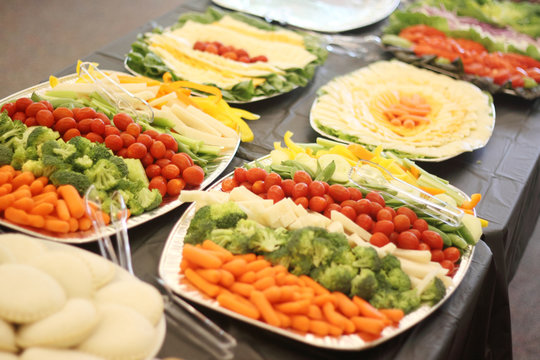 Vegetable and cheese appetizers on trays.