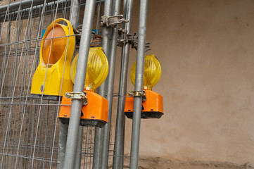 Bauleuchten hängen an Absperrgittern