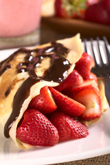 Crepe filled with fresh strawberries, chocolate sauce on top