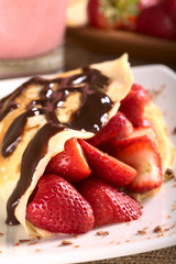 Crepe filled with fresh strawberries, chocolate sauce on top