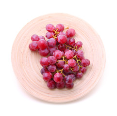 Image of red grape bunch in plate over white