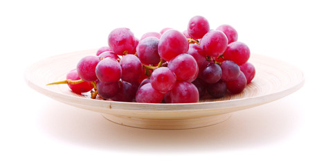 Image of red grape bunch in plate over white