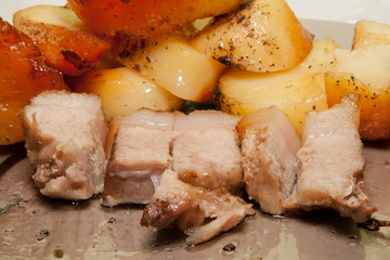roast pork and potatoes on a baking sheet