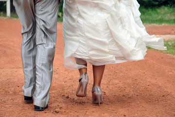 Bride and groom walking on dust road