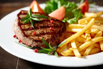 Foto op Plexiglas Steakhouse Gegrilde biefstuk met frietjes