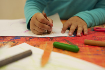 Kind malt mit Wachsmalkreide