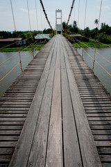 Hanging bridge across the river in Thailand .