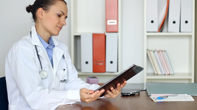 Portrait of female doctor with tablet computer in her office