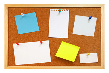 Blank notes with colorful push pins on framed cork board isolate