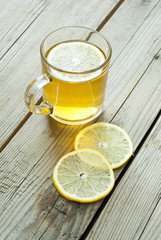 cup of tea and sliced lemon on wooden table