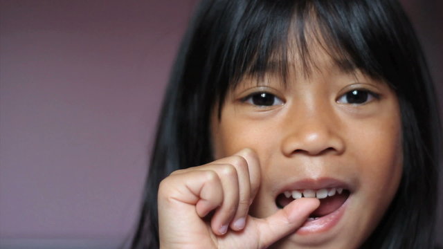 Asian Girl Wiggling Her First Loose Tooth-Close Up