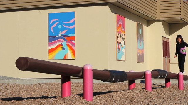 Little Asian Girl On A Wiggly Playground Balance Beam