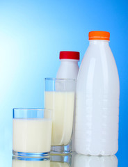 Tasty milk in glasses and bottle on blue background