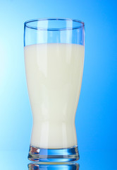 Tasty milk in glass on blue background