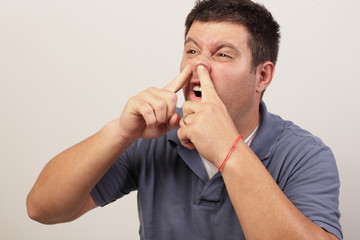Image of a man picking his nose with two fingers