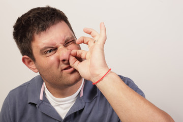Man painfully picking his nose hair