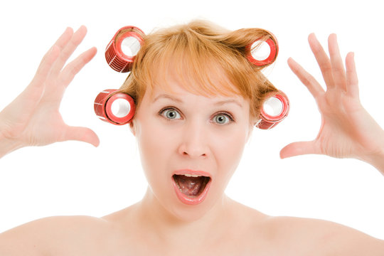 Woman in curlers moans on a white background.